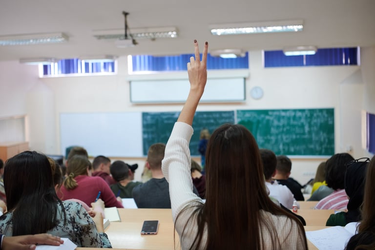 a woman raising her hand up in a classroom