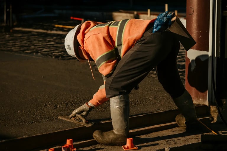 a construction worker is working on a concrete sidewalk