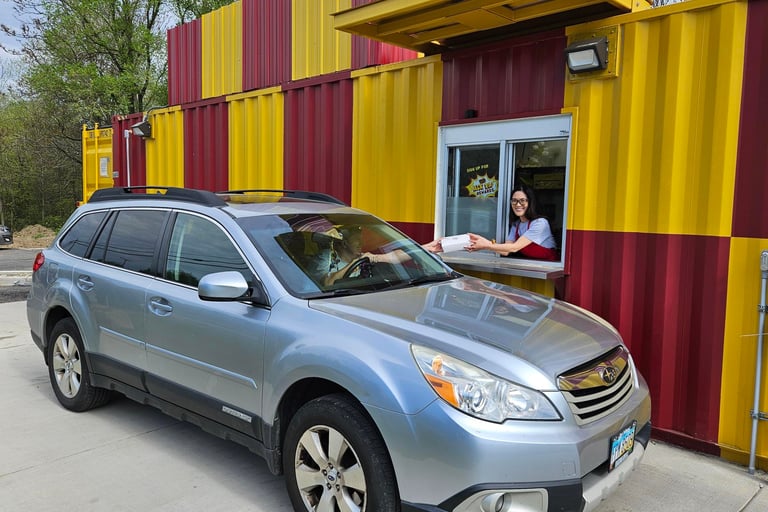 Bright red and yellow HeckYA shipping container drive-through restaurant on McCartney Rd Youngstown