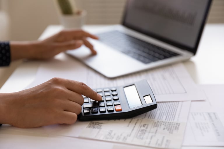 Someone in Front of Laptop Using Calculator