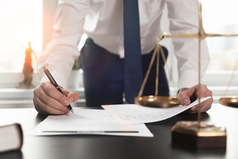 Person Writing in Front of Scales of Justice