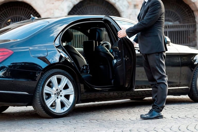 a man in a suit and tie is standing in front of a car