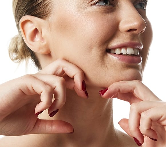 Woman smiling and cupping her chin, indicating satisfaction with facial contour.