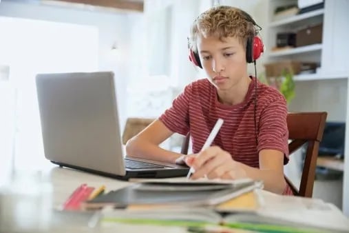 a boy with headphones and headphones on a laptop