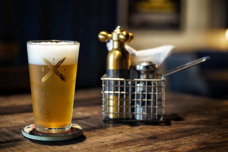 A close-up shot of a glass of cold beer on a restaurant table, indicating a casual dining atmosphere