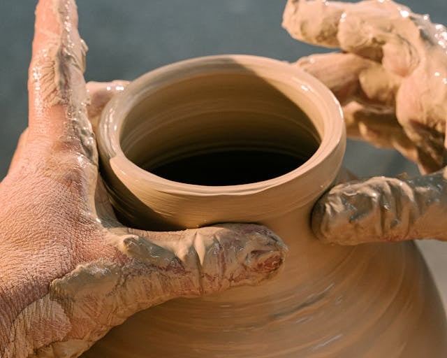 a person holding a clay potted potted with a clay potted potted