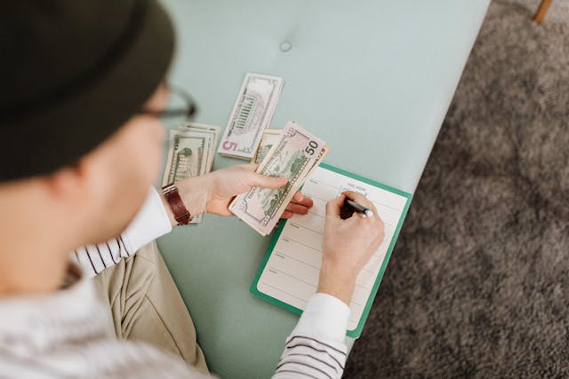 a man in a hat and a notebook with money