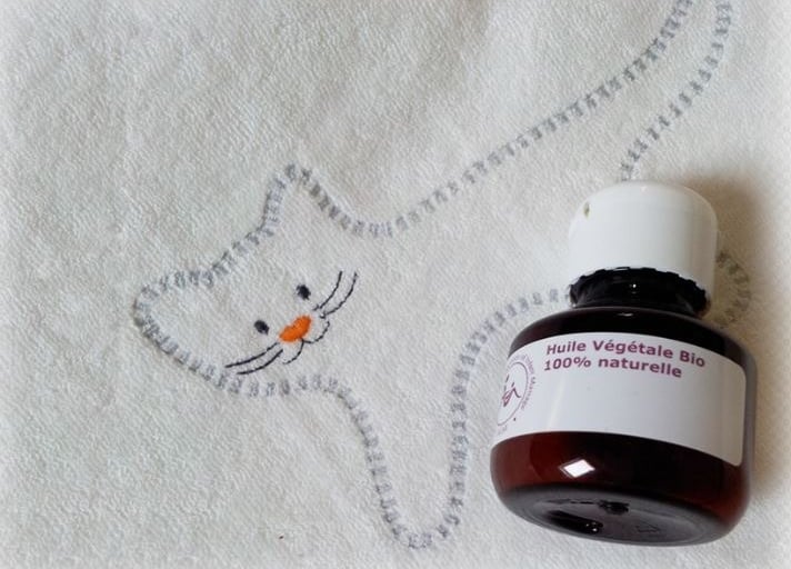 Flacon d'huile de massage posé sur un dessin de chat