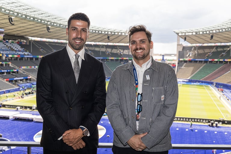 Sami Khedira (ex German footballer) and Tim Dougill posing for a photo in front of Berlin Stadium. 