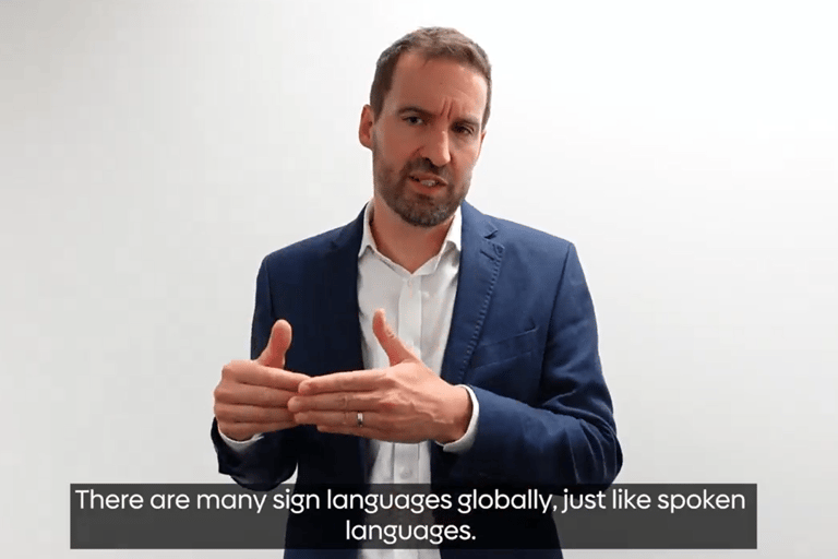 Rik Robarts a male in his mid forties sign languages to camera.