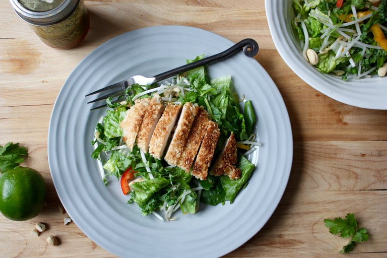 Thai garden salad topped with sliced sesame chicken