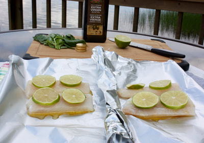 uncooked fish topped with lime slices sitting on tinfoil