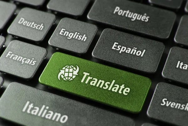 Close-up of a computer keyboard with a green translate button and language options.