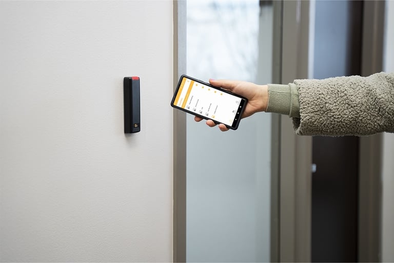 User accessing a secured door using the ProdataKey mobile app with a Bluetooth-enabled reader for cloud-based access control
