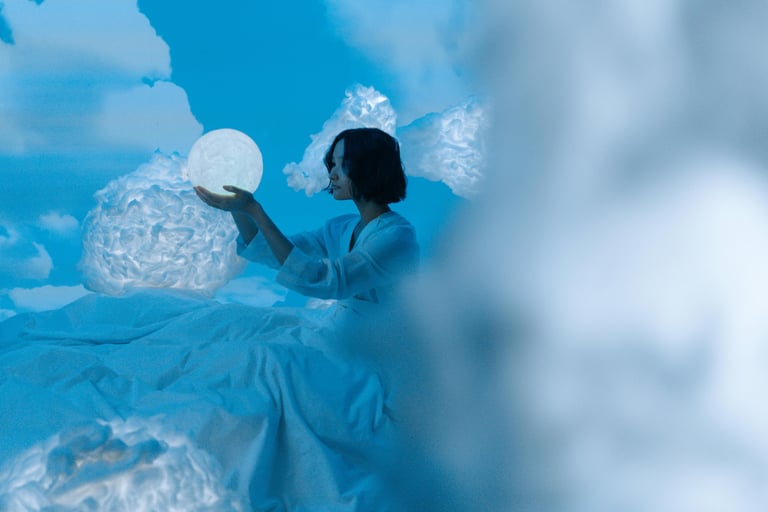 une femme en robe blanche assise sur un nuage pour l'Alliance de la sophrologie et de l'analyse