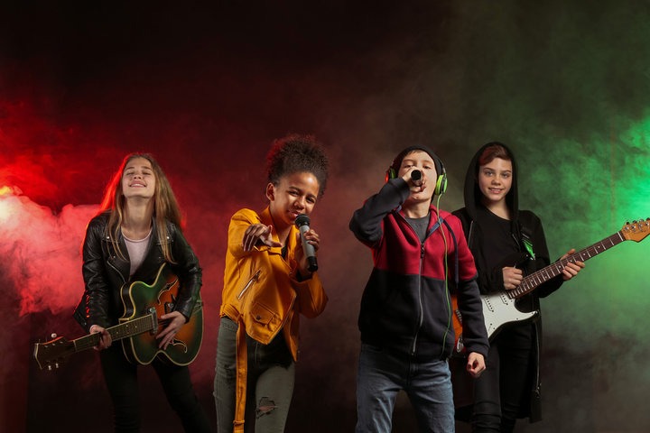 a group of kids singing and playing guitar