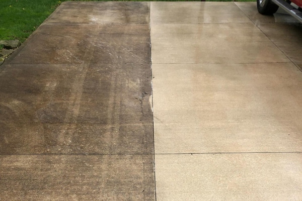 an image showing half of a driveway pressure washed, while showing the other half still dirty