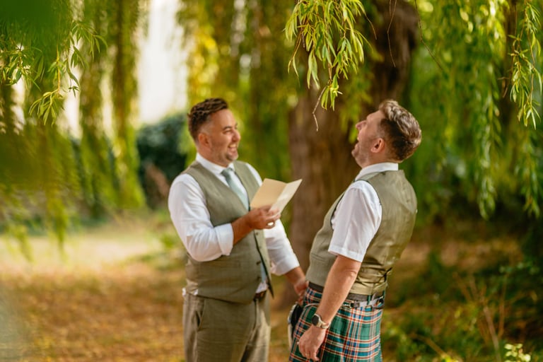 Groom reading a wedding letter to his spouse at Tall John’s House, filled with laughter and true emotion