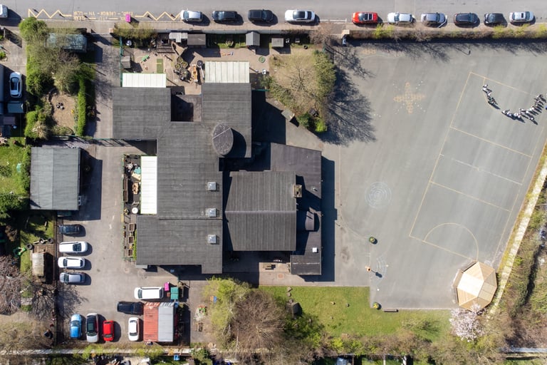 Aerial drone shot of the school from above. You can see the roof and playground.