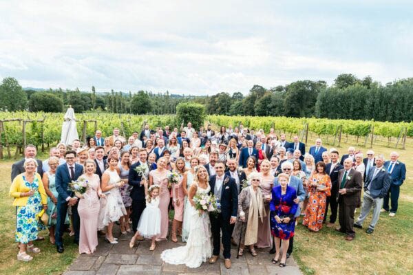 The everyone photo. All wedding guests standing in front of Llanerch vineyard.