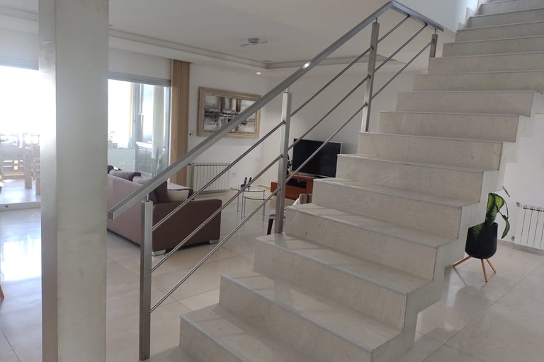 una escalera con una baranda en acero inoxidable