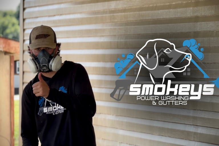 Owner of Smokey’s Power Washing holding a thumbs up with business logo to his right