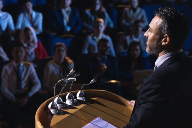 a man in a suit and tie is standing at a podium with microphones