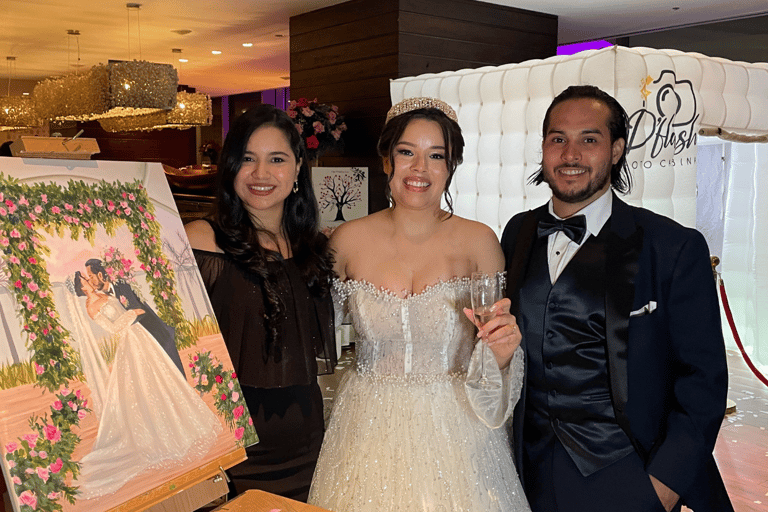 pareja de esposos posando junto a la pintora y su obra de arte en una boda en panama