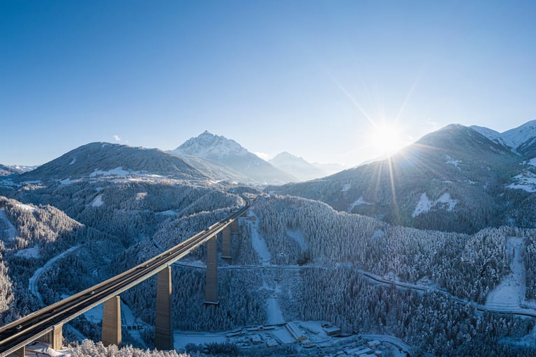 a train traveling over a bridge over a mountain