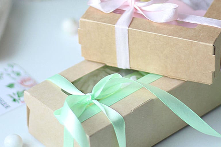a pair of boxes with a pink ribbon tied to them