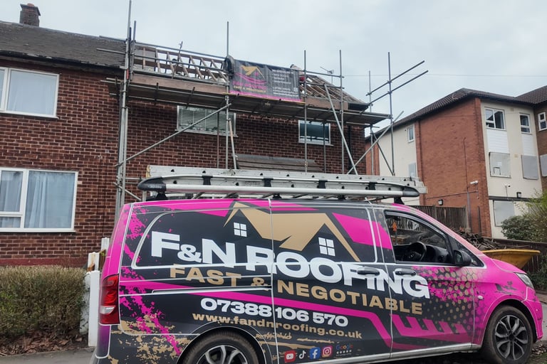 Professional roofing contractors repairing a brick house roof with scaffolding and a branded F&N Roofing van.