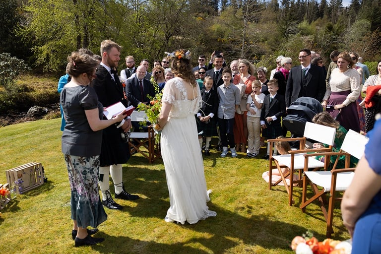 a bride and groom are standing in front of a crowd of people