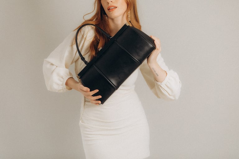 a woman in a white dress and a black purse