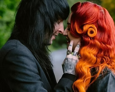 alt couple, one with black hair and the other with red to orange ombre hair