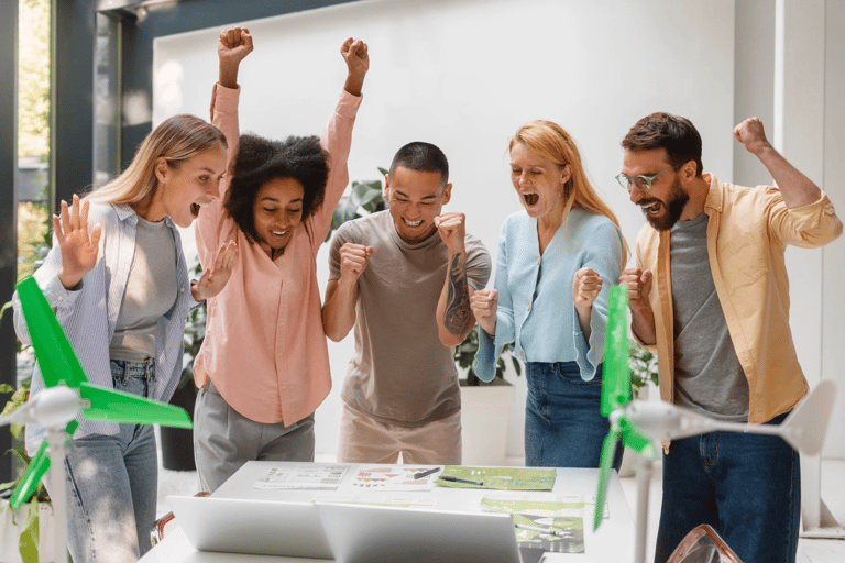 Jovens lĂderes celebrando resultado de trabalho colaborativo