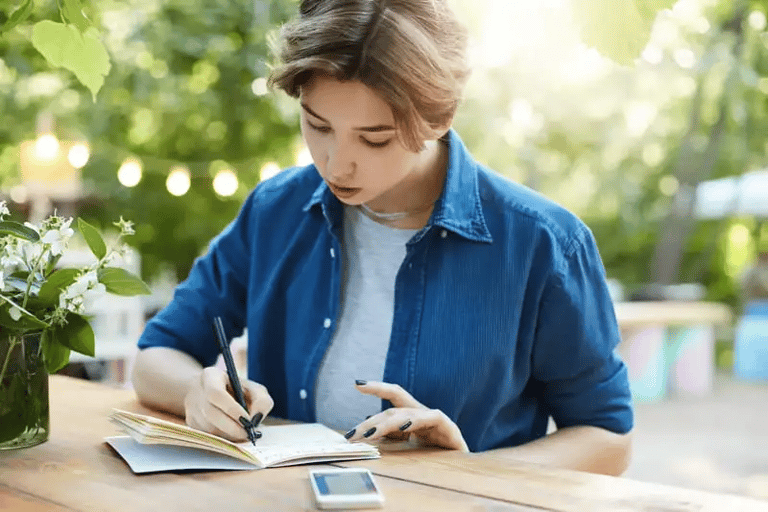 Pessoa treinando frases assertivas em um caderno