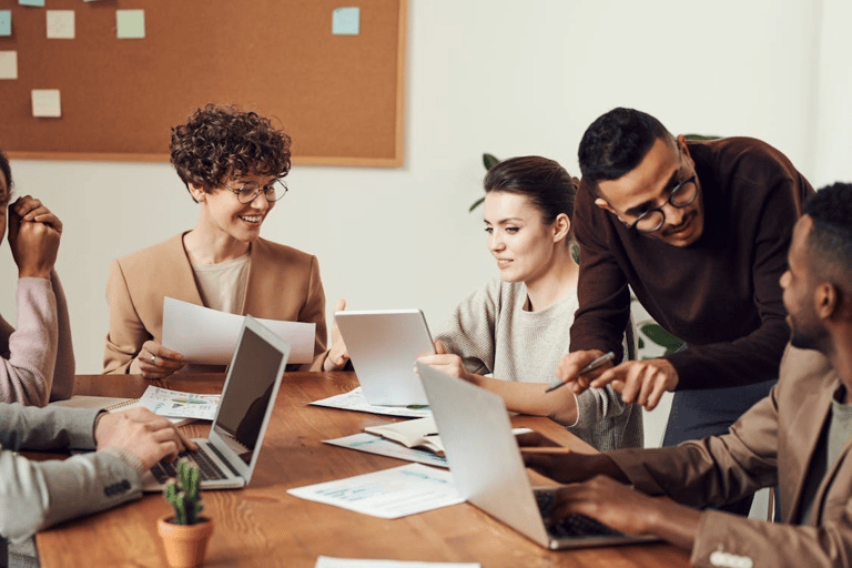 Equipe diversa trocando feedback de forma horizontal e respeitosa