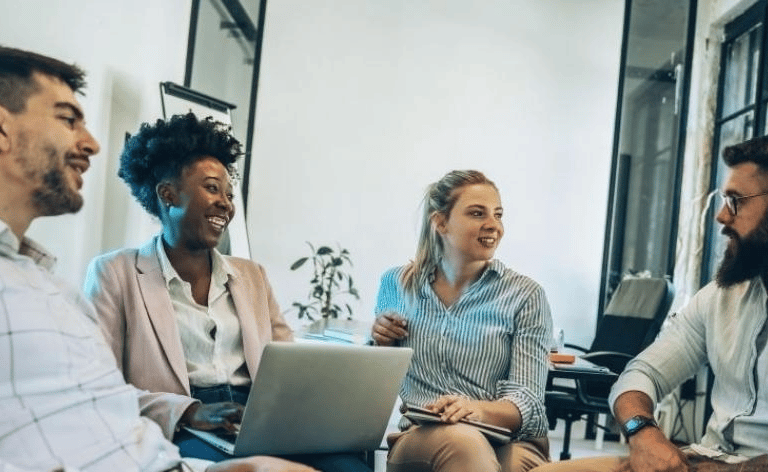 Líder jovem conduzindo reunião com equipe diversa, aplicando liderança situacional.