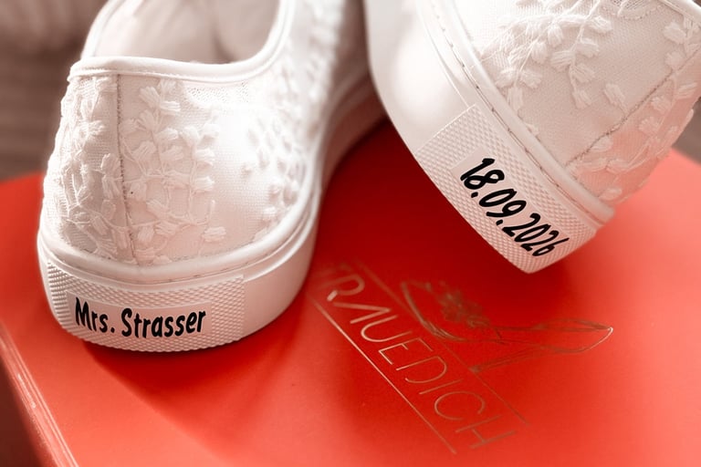 a pair of white sneakers with a red box on top of a red box