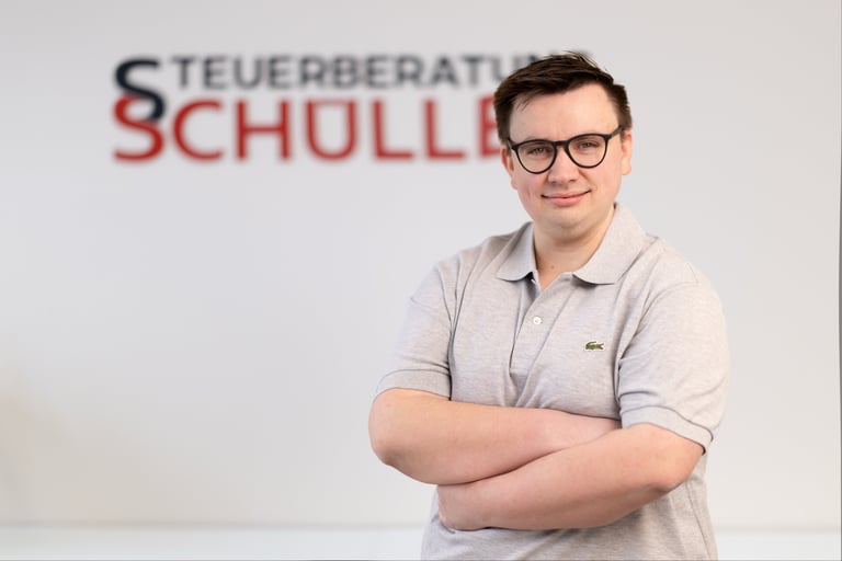 Benedikt Zimmermann, Steuerfachwirt im Hintergrund Schriftzug Steuerberatung Schüller