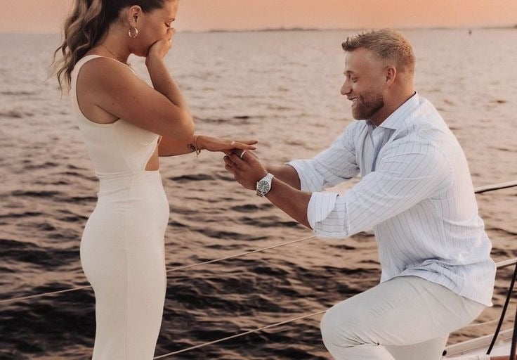 a man and woman on a boat in the ocean proposal 
