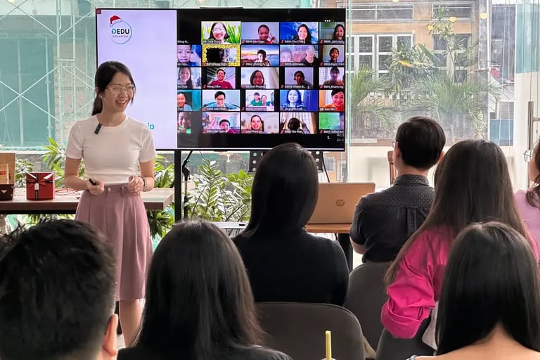 a woman in a white shirt is standing in front of a group of people