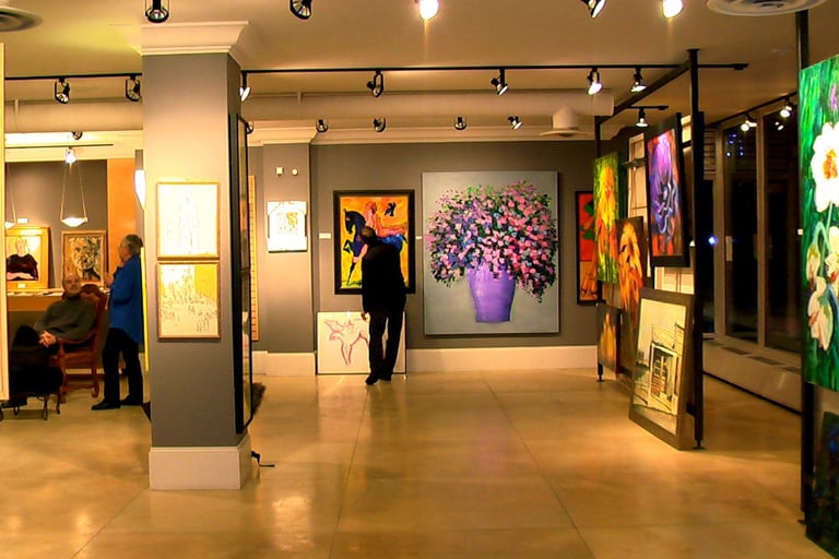 a person standing in a room with paintings on the walls in Mount Royal Calgary