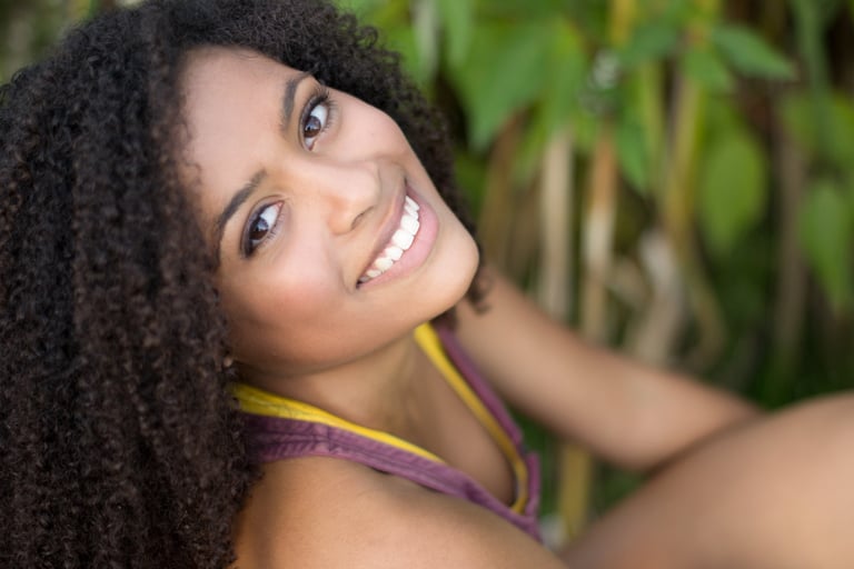 a woman with curly hair and a yellow top