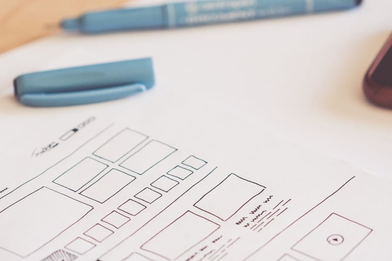 a paper wireframe and pen on a desk