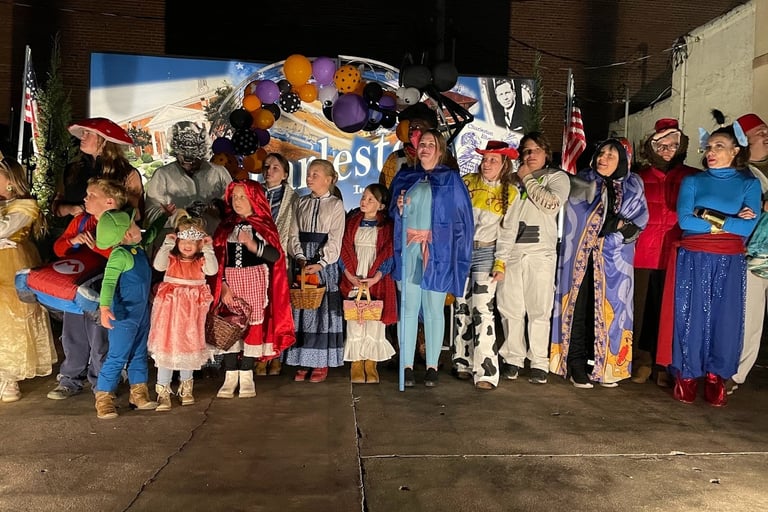 Charleston Halloween Costume Contests participants in front of the sign in Main Street Park.