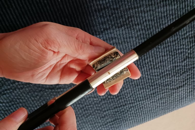 A person holding a rosin in their hand while rosining their bow