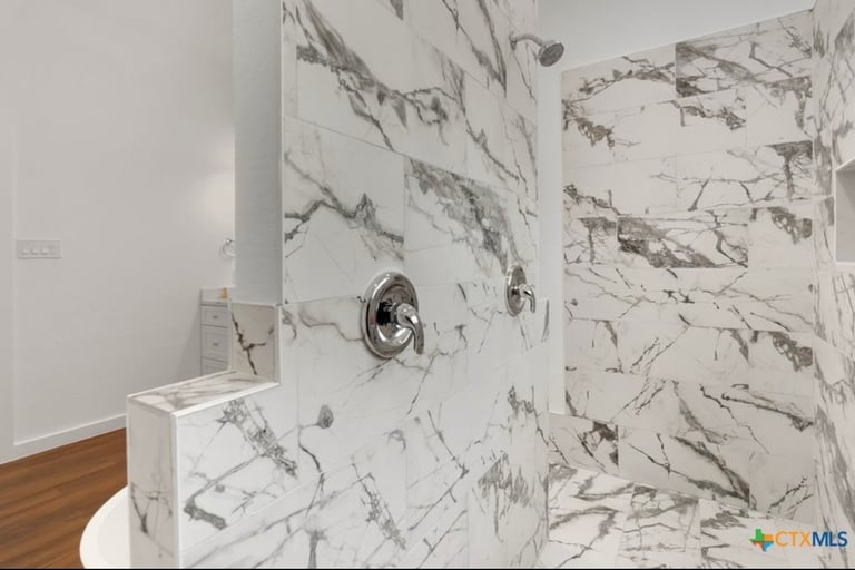 Luxurious double-headed shower in primary bathroom of custom home