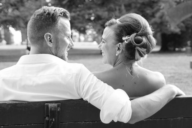 La mariée et le marié se regardent en riant, photo en noir et blanc prise à dijon.