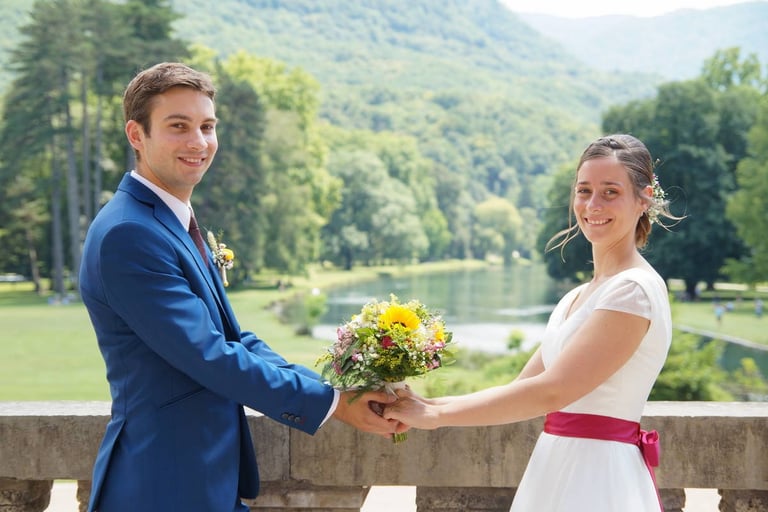 Couple de mariés souriants avec un bouquet champêtre